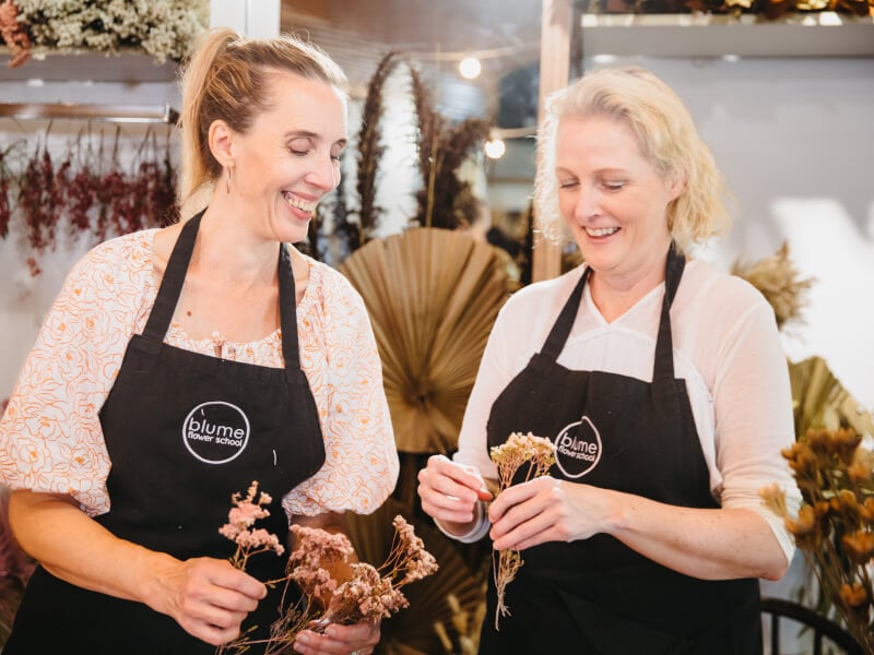 Mother and daughter wearing aprons in a florist together